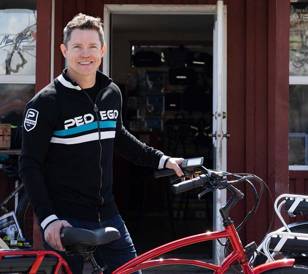Owner stands with ebike next to Pedego store.
