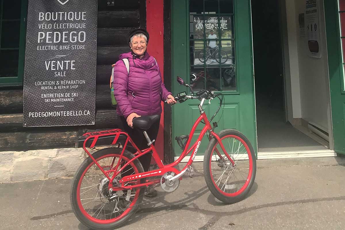 Cecile-Auger-Pedego-Canada-Commuter-Montebello Woman wearing helmet with red Pedego Boomerang ebike
