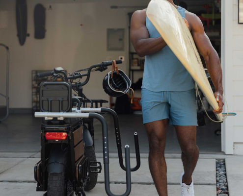 Surfer loads up board on Pedego cargo ebike